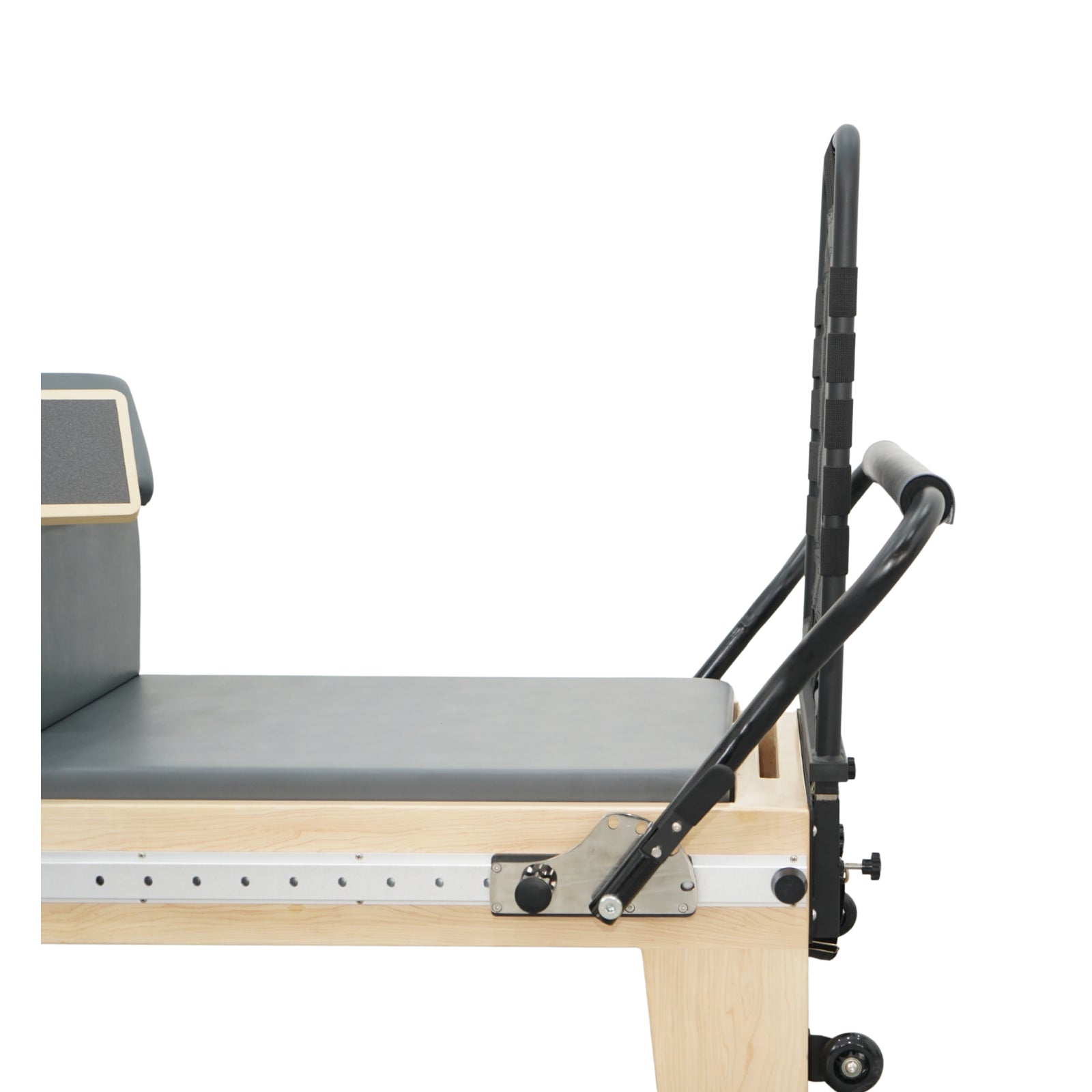 Close-up of the adjustable heavy-duty footbar and high-density padded carriage on the Timber Plus reformer.