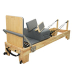 Rear view of Grove oak reformer, highlighting the sturdy wooden risers and professional rope system.