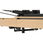 Precision pulley risers and smooth maple wood track system of Nestor reformer for quiet exercise movement