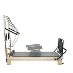 Timber Plus maple wooden master pilates reformer with stainless steel half tower and grey upholstery, professional studio grade equipment.